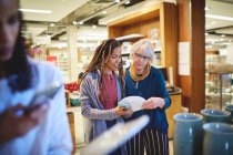 Women shopping for plates in home goods store — Stock Photo