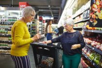 Seniorinnen kaufen im Supermarkt ein — Stockfoto