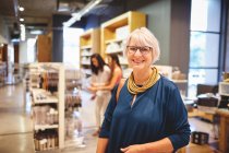 Portrait souriant confiant femme âgée faisant du shopping dans un magasin de biens à la maison — Photo de stock