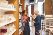 Lavoratrice che aiuta le donne a fare shopping nel negozio di articoli per la casa — Foto stock