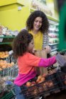 Compras de comestibles madre e hija en el supermercado - foto de stock