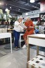 Femmes âgées avec tablette numérique et téléphone intelligent achats dans le magasin de biens à la maison — Photo de stock