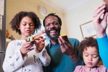 Portrait happy father and daughters eating cupcakes — Stock Photo