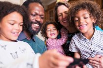 Famiglia multietnica felice utilizzando lo smartphone — Foto stock