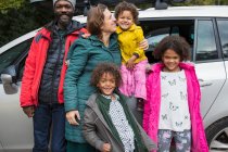 Porträt glückliche multiethnische Familie steht vor Auto — Stockfoto