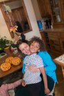 Retrato feliz madre e hijo abrazándose en la mesa con calabazas de Halloween - foto de stock