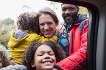 Портрет счастливой многонациональной семьи у окна автомобиля — стоковое фото