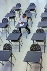 Estudiante de secundaria dedicado a tomar examen en el escritorio en el aula - foto de stock