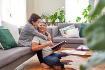 Zärtlich reifes Paar liest und spricht im Wohnzimmer — Stockfoto