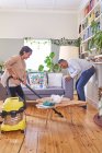 Ältere Paare staubsaugen und reinigen Wohnzimmer — Stockfoto