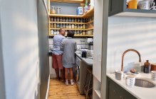 Paar redet und spült in Küche — Stockfoto