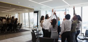 Business people cheering in huddle in office meeting — Stock Photo