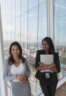 Ritratto donna d'affari fiduciosa alla finestra dell'ufficio grattacielo — Foto stock