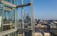 Uomo d'affari che parla su smart phone al sole finestra grattacielo moderno — Foto stock