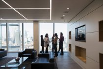 Деловые люди разговаривают в современном офисном холле — стоковое фото