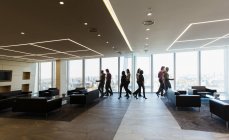 Empresários caminhando no moderno lobby de escritório — Fotografia de Stock