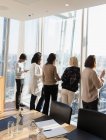 Geschäftsleute unterhalten sich am sonnigen Konferenzzimmerfenster — Stockfoto