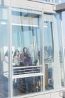 Geschäftsleute unterhalten sich am sonnigen Bürofenster — Stockfoto