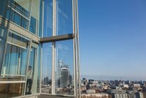Бізнесмен використовує смартфон у сонячному високогірному офісному вікні — стокове фото
