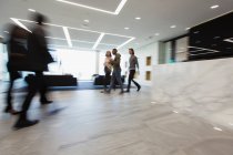 Les gens d'affaires marchent dans le hall du bureau — Photo de stock