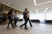Uomini d'affari che camminano nella hall dell'ufficio — Foto stock