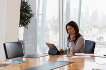 Выделенная деловая женщина с цифровым планшетом в конференц-зале — стоковое фото