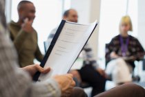 Close up businessman holding paperwork in office meeting — Stock Photo