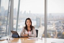 Portrait confident businesswoman working in urban conference room — Stock Photo