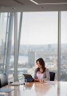 Donna d'affari che utilizza tablet digitale in sala conferenze urbano grattacielo — Foto stock