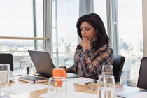 Сфокусированная деловая женщина с ноутбуком в конференц-зале — стоковое фото