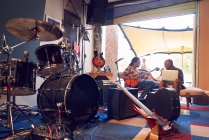 Músicos do sexo masculino praticando em estúdio de gravação de garagem — Fotografia de Stock