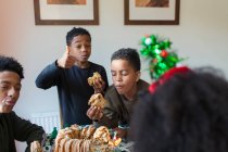 Hungry brothers eating Christmas bread — Stock Photo