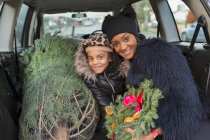 Portrait happy mother and daughter with Christmas tree in car — Stock Photo