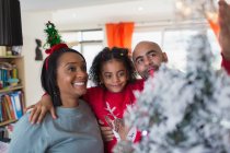 Glückliche Familie schmückt Weihnachtsbaum — Stockfoto