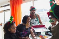 Fröhliche Familie backt und isst Weihnachtsplätzchen am Tisch — Stockfoto