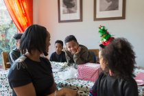 Felice famiglia avvolgendo regali di Natale a tavola — Foto stock