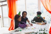 Mutter und Kinder backen Weihnachtsplätzchen am Tisch — Stockfoto