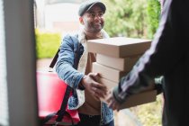 Entrega hombre entrega pizzas en la puerta principal - foto de stock