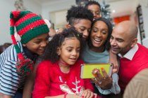 Familia feliz tomando selfie de Navidad con teléfono inteligente - foto de stock