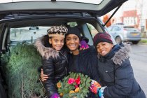 Porträt glückliche Mutter und Kinder mit Weihnachtsbaum und Kranz — Stockfoto