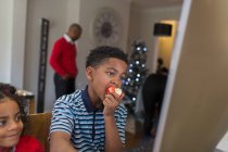 Мальчик ест яблоко дома — стоковое фото