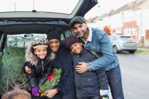 Porträt glückliche Familie lädt Weihnachtsbaum ins Auto — Stockfoto