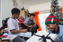 Родина відкриває різдвяні подарунки у вітальні — стокове фото