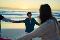 Famille heureuse à l'extérieur dans la plage du coucher du soleil — Photo de stock