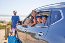Ritratto famiglia felice in auto sulla spiaggia soleggiata — Foto stock
