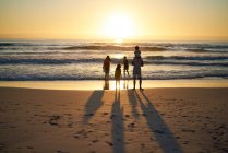 Family wading in summer ocean surf at sunset — Stock Photo