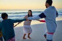 Щаслива сім'я тримає руки в колі на пляжі — стокове фото