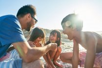 Família feliz jogando na praia ensolarada — Fotografia de Stock