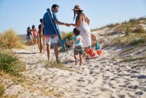 Família caminhando na praia ensolarada — Fotografia de Stock