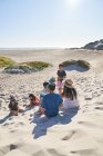 Famille jouant et se relaxant sur la plage ensoleillée, Cape Town, Afrique du Sud — Photo de stock